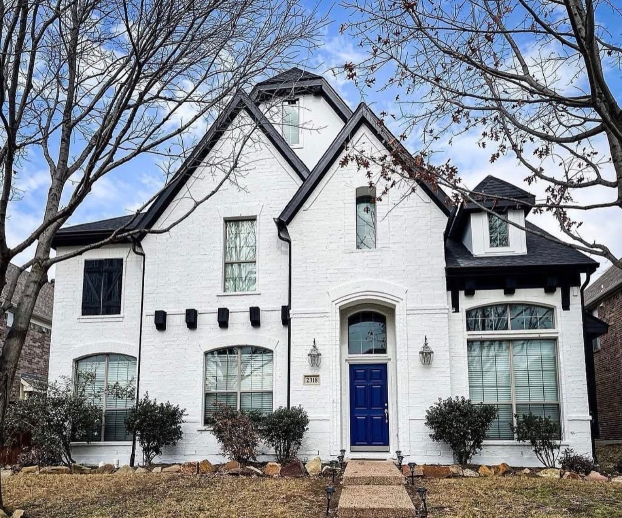 House with white brick finish and dark trim after the refresh
