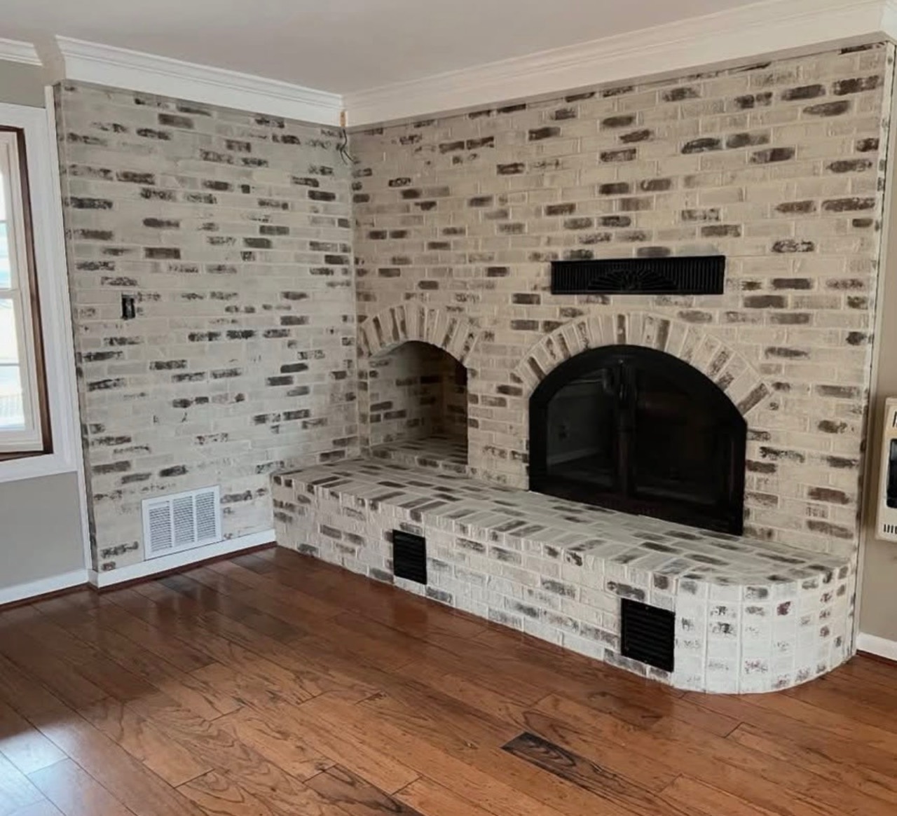 Brick fireplace and hearth with a light decorative finish
