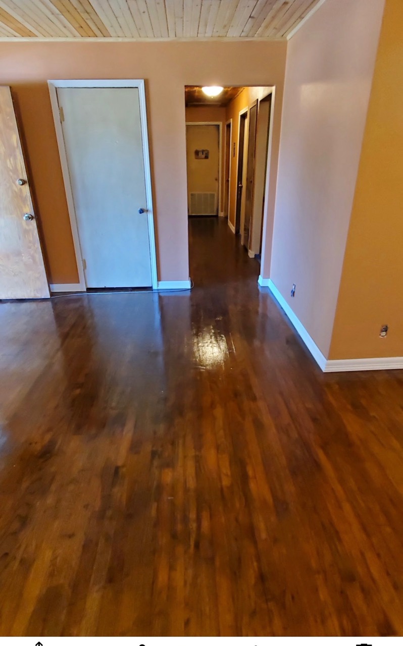 Refinished wood floor with a warm tone and glossy surface